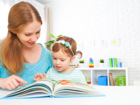 mother and child reading book at home